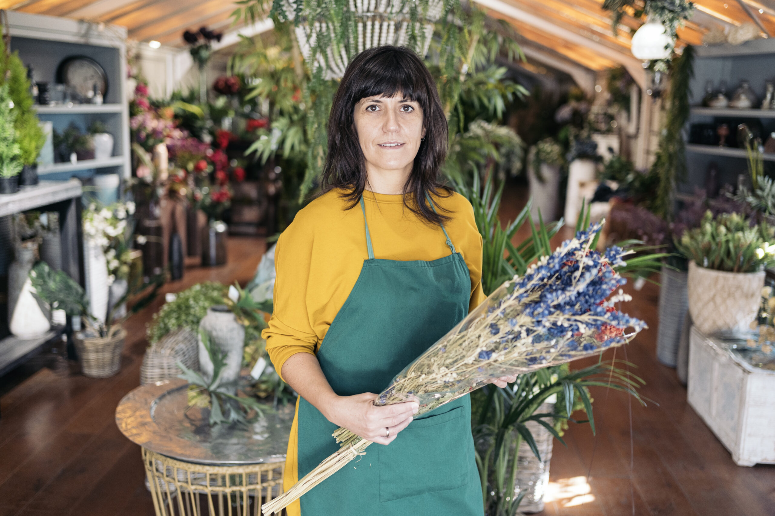 Stock photo of beautiful and happy woman holding a bouquet of flowers and looking at camera.
